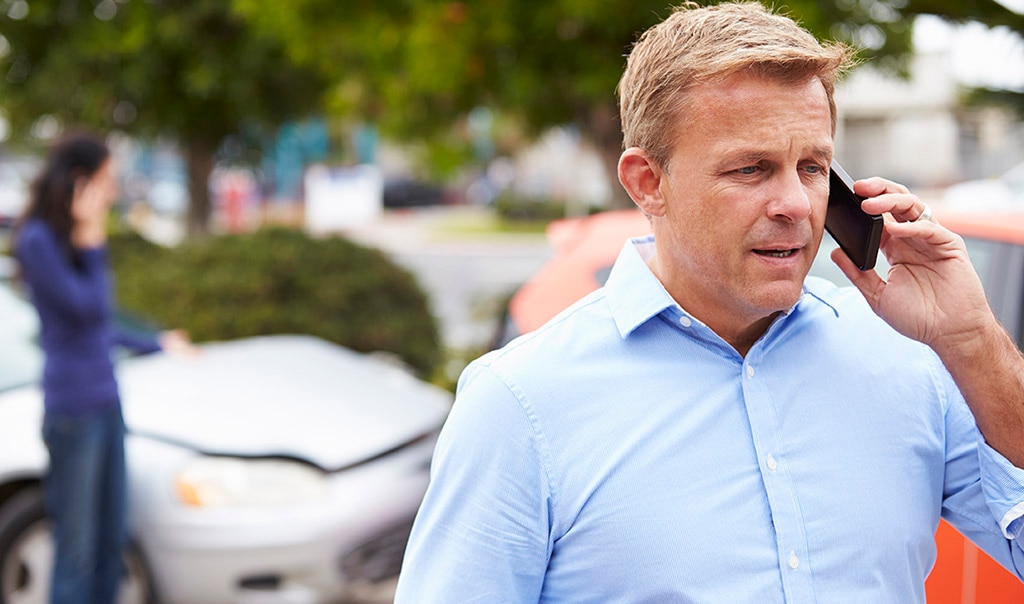 man waring blue shirt, phone in left hand