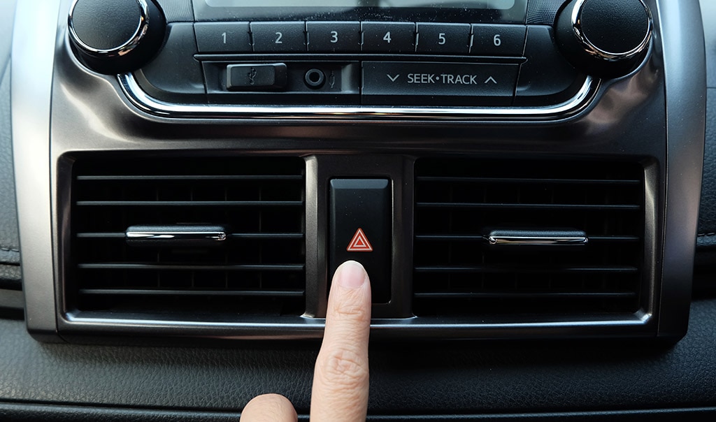 finger pushing flashers in car