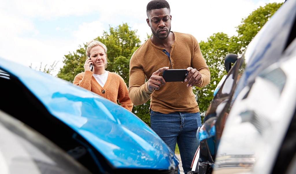 man in taking pictures of car damage