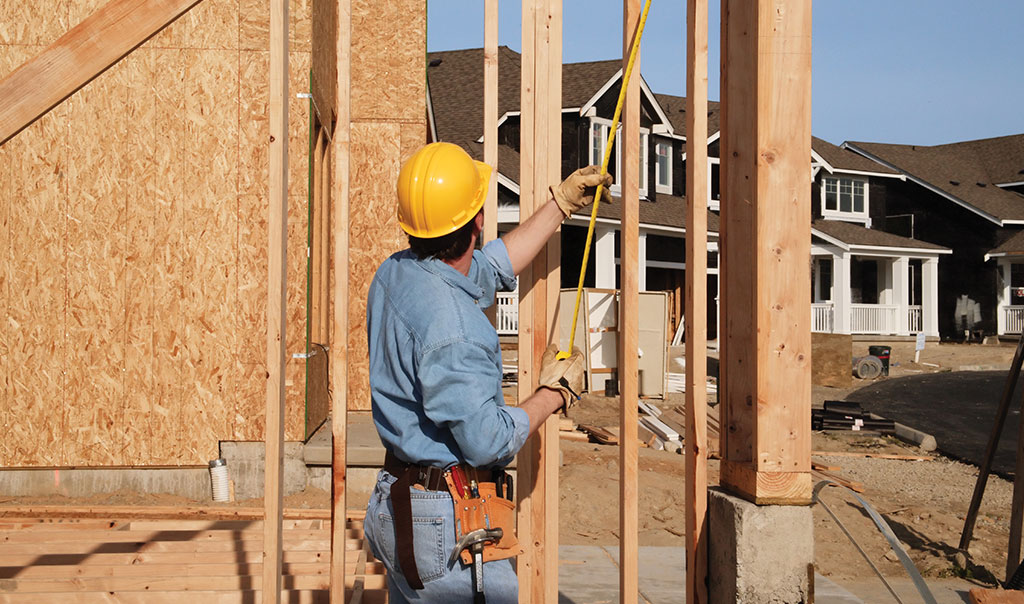 Image of builder working on home with exterior post