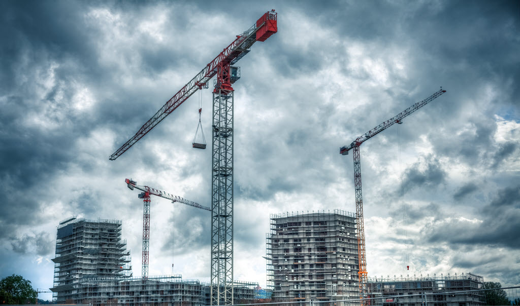 two skycrapers, two cranes, red crane