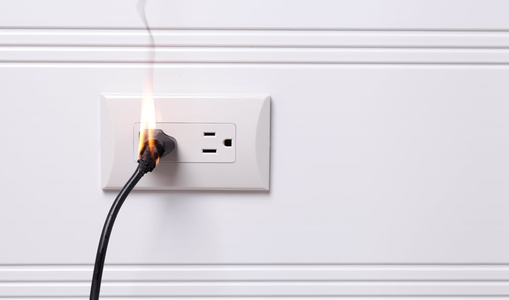 white wall outlet, black plug with fire