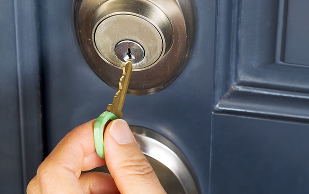 Hand putting a key in a front door