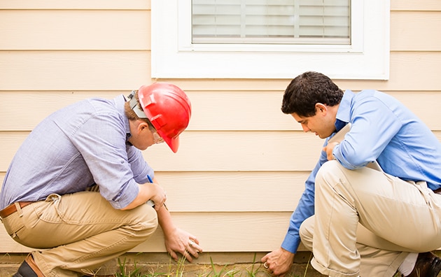Home inspector checking exterior of home